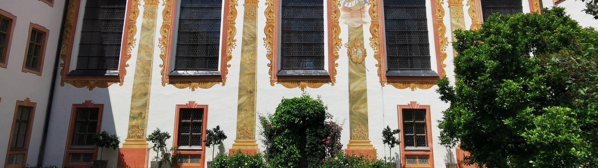 Im Innenhof des Klosters Beuerberg mit Blick auf den Zwiebelturm der Klosterkirche und die reich bemalte Fassade, © Tölzer Land Tourismus|Foto: Johanna Kirschenhofer Im Innenhof des Klosters Beuerberg mit Blick auf den Zwiebelturm der Klosterkirche und die reich bemalte Fassade, © Tölzer Land Tourismus|Foto: Johanna Kirschenhofer