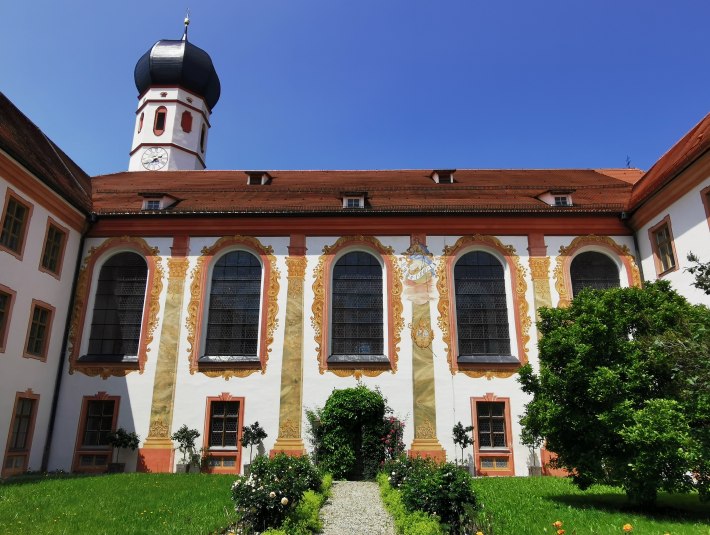 Im Innenhof des Klosters Beuerberg mit Blick auf den Zwiebelturm der Klosterkirche und die reich bemalte Fassade, © Tölzer Land Tourismus|Foto: Johanna Kirschenhofer